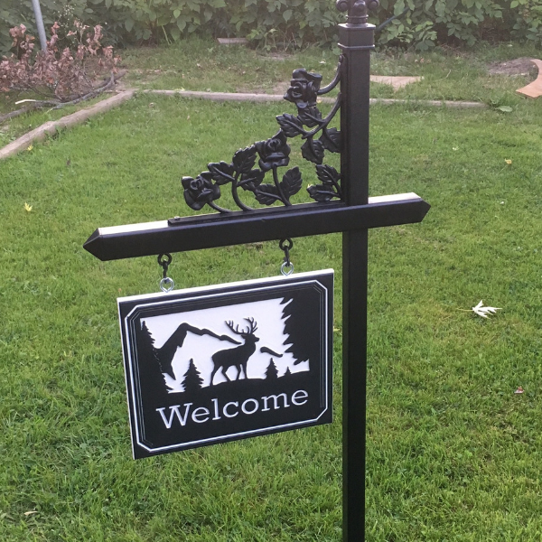 A black lawn sign holder with one of our stock engraved welcome plaques