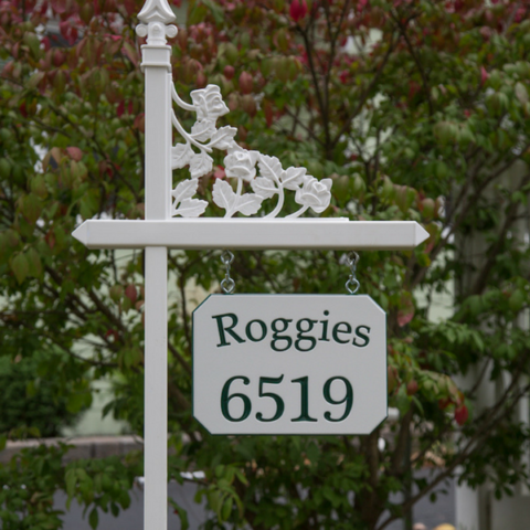 Custom green and white engraved sign with family name and house number on one of our white lawn sign holders with rose scroll