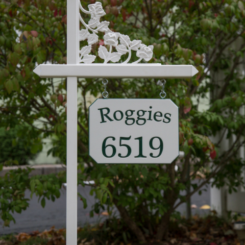 White lawn sign holder with a customized sign showing a special family name with a slight arch on white-green-white color core